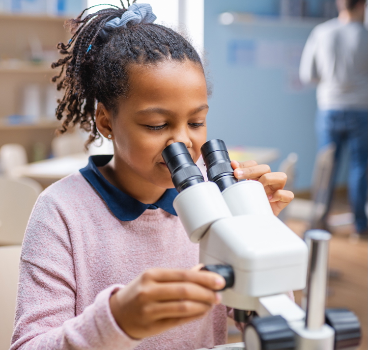 female kid looking through microscope female kid looking through microscope