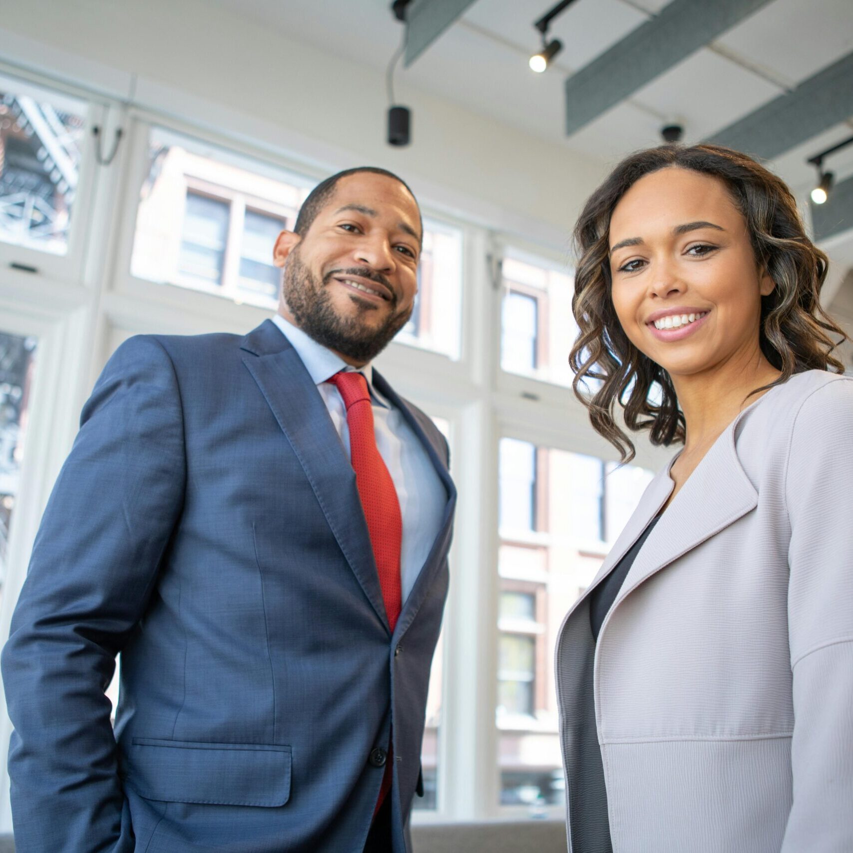 A businessman and woman wearing suits in a corporate building